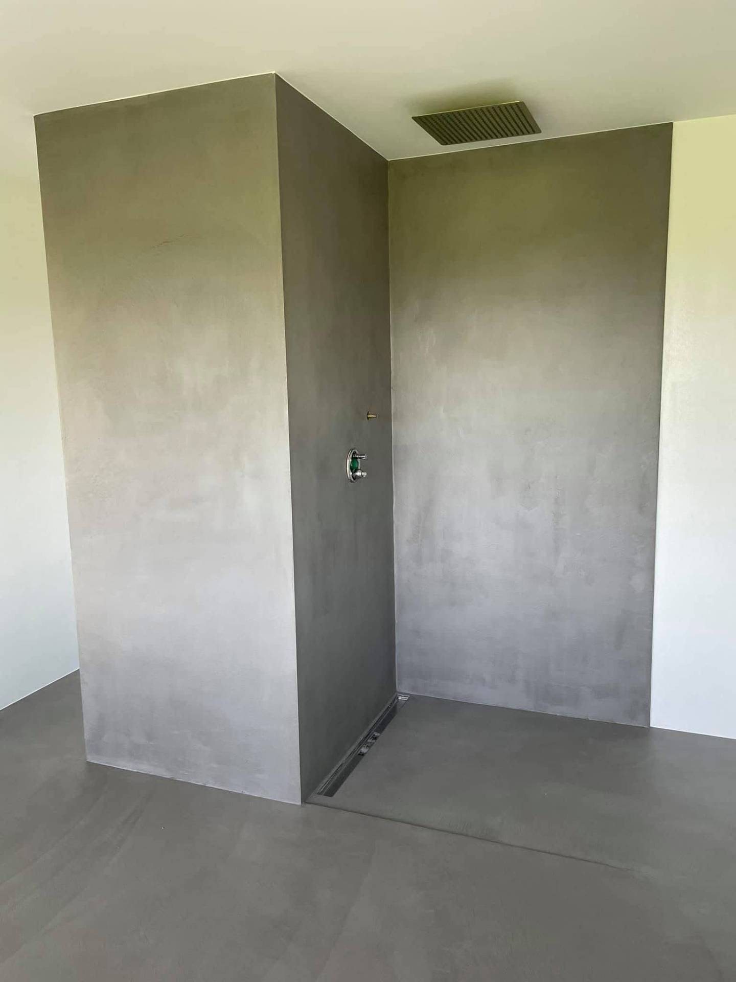 Fugenlose Dusche aus grauem Mikrozement, nahtloser Wand-Boden-Übergang